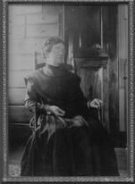 SA0065 - Alice Smith was from the Church Family. This is a framed portrait of her seated in chair; a cupboard is in the background., Winterthur Shaker Photograph and Post Card Collection 1851 to 1921c